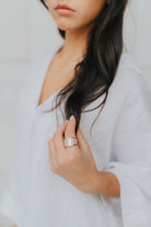 Close-up of the ring's inlay and band edge showing the mother-of-pearl panels set into the wide gold-tone band and smooth interior finish.