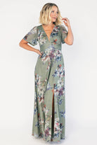 Model wearing a sage floral maxi dress with a deep V-neckline, short flutter sleeves, and an empire waist.