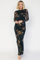 Black mesh bodycon midi dress with muted gold floral print, sheer long sleeves, a round neckline, flattering side ruching, and a thigh-high side slit.