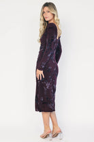 Model wearing a dark plum velvet floral midi dress with a boat neckline, long sleeves, and a fitted silhouette.