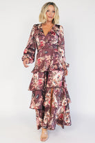 Clove satin maxi dress with a mauve floral print, V-neckline, short sleeves, a smocked back, and a flowing tiered ruffle skirt.