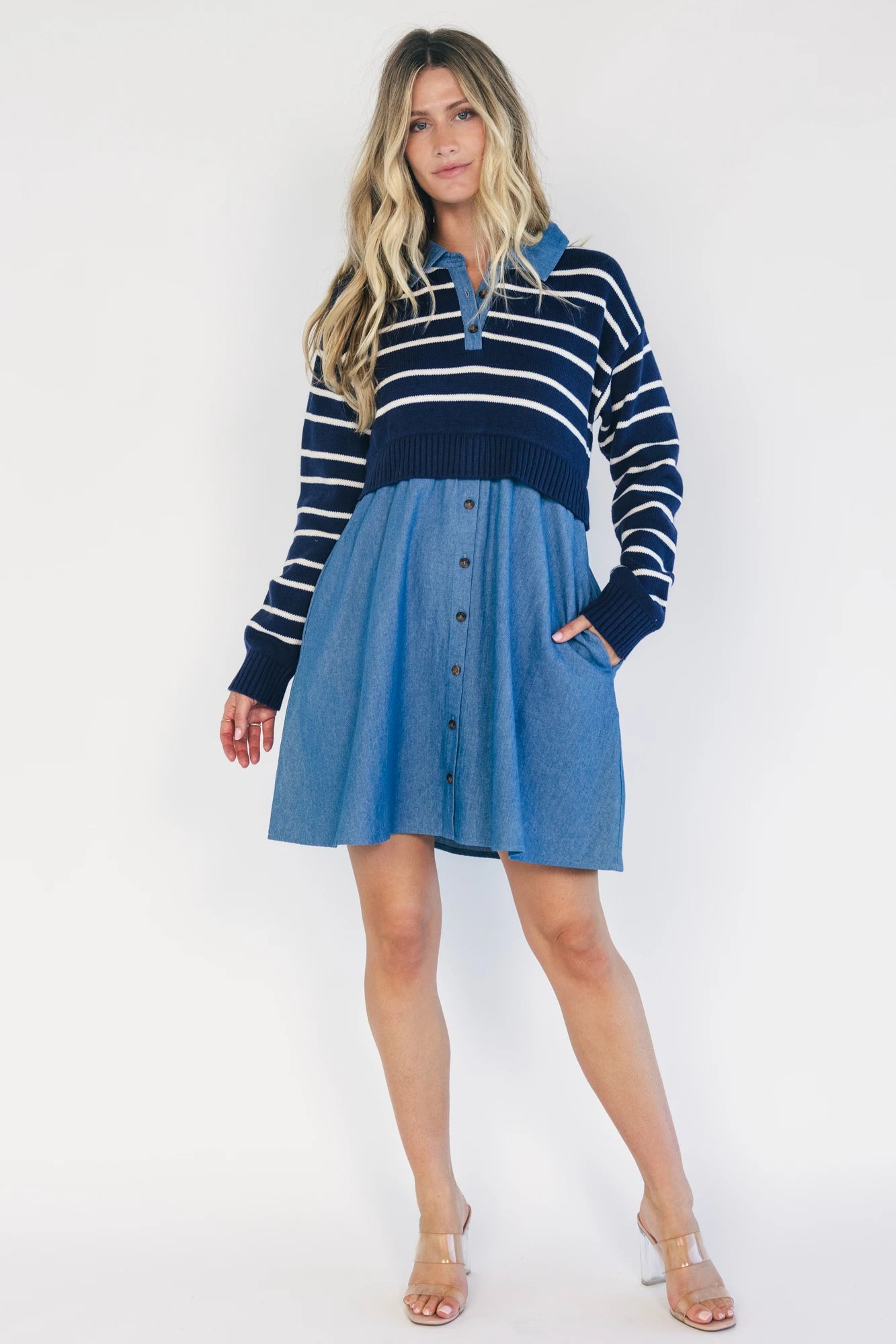 Model wearing a navy and ivory striped sweater dress with a collared neckline, functional button-front detail, long sleeves, and an elastic waist.