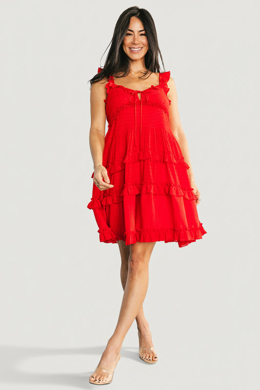 Front view of red Andalucía short dress with ruffled sweetheart neckline, V-notch tie, and tiered ruffle skirt on model, studio background.