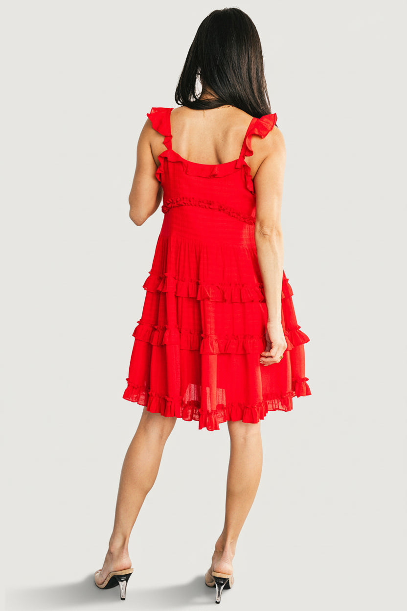 Close-up of ruffled sweetheart neckline and V-notch tie on red Andalucía short dress, showing textured light-grid polyester fabric.