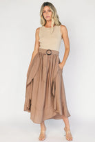 Model wearing the Stacy Midi Dress in Taupe + Mocha featuring a ribbed taupe knit bodice with a bateau neckline and a flowing woven midi skirt.