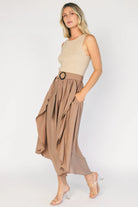 Model wearing the Stacy Midi Dress in Taupe + Mocha featuring a ribbed taupe knit bodice with a bateau neckline and a flowing woven midi skirt.