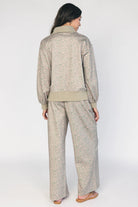 Model wearing the Diana Lounge Set in Olive Floral featuring a matching long-sleeve half-zip top and wide-leg pants.