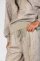 Model wearing the Diana Lounge Set in Olive Floral featuring a matching long-sleeve half-zip top and wide-leg pants.
