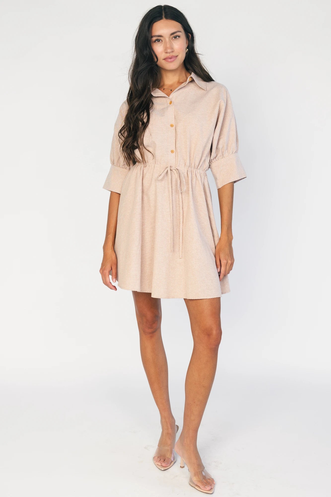 Model wearing the Beekman Short Dress in Natural Stripe featuring a collared neckline, functional button-front closure, elbow-length sleeves with wide cuffs, and a removable waist tie.