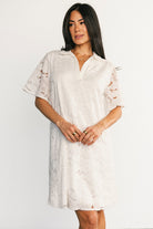 Lifestyle image of Calida Lace Dress in off-white worn outdoors, highlighting airy lace pattern and versatile day-to-night styling.