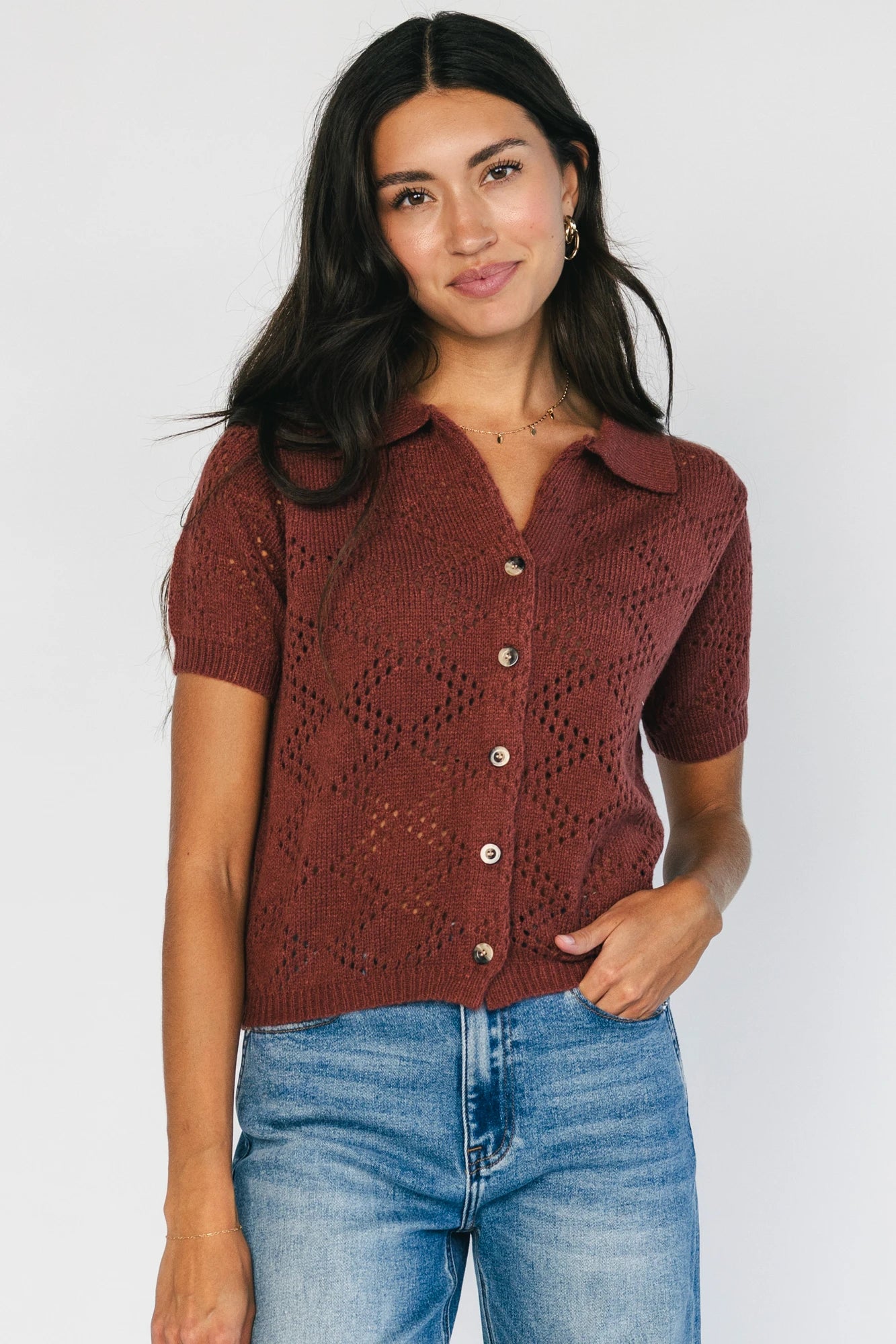 Model wearing a dark clay openwork knit cardigan with a V-neckline, short sleeves, five-button front closure, and a relaxed silhouette.