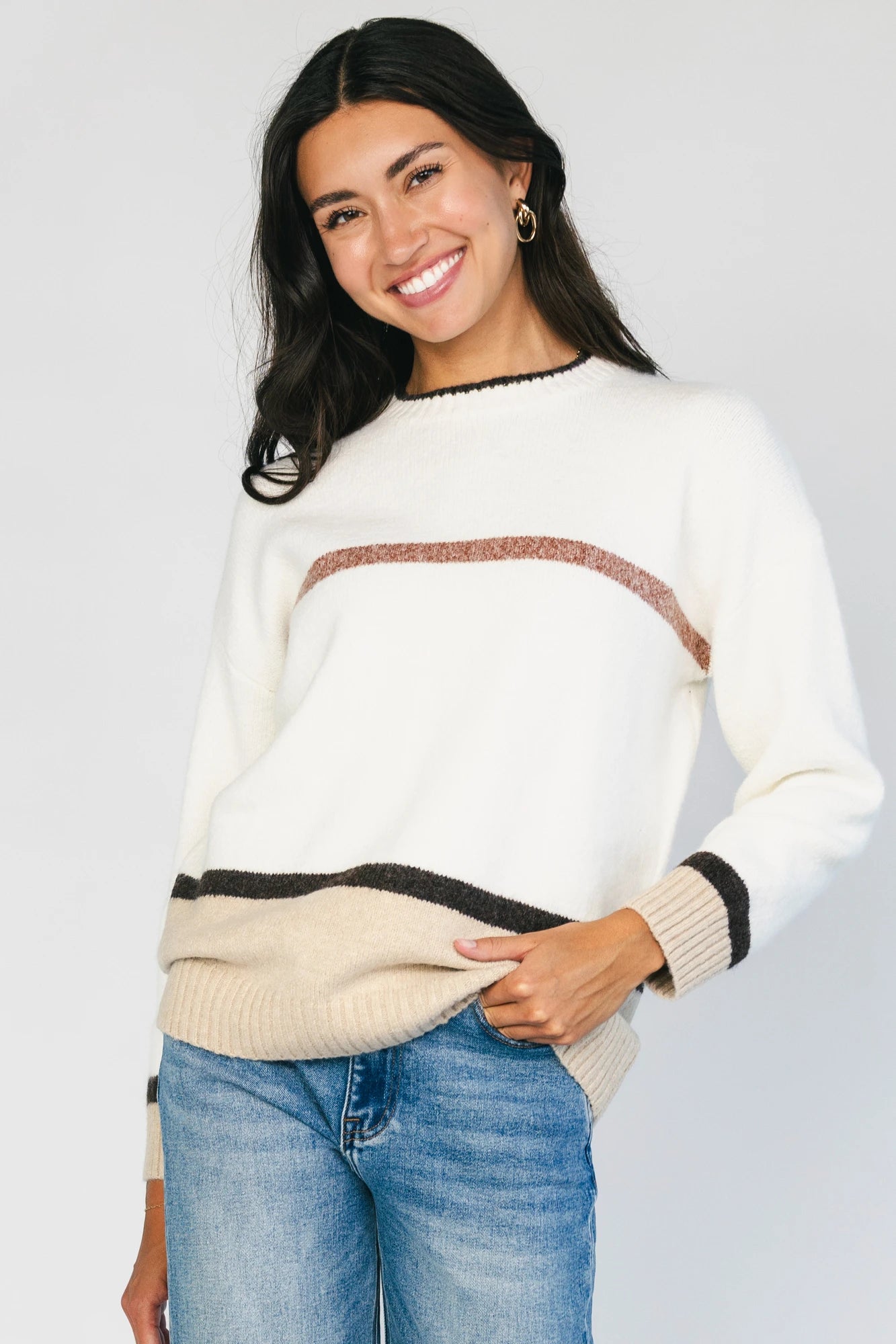 Natural color-block sweater with horizontal tan and brown stripes, a round neckline, long sleeves, and a relaxed fit.