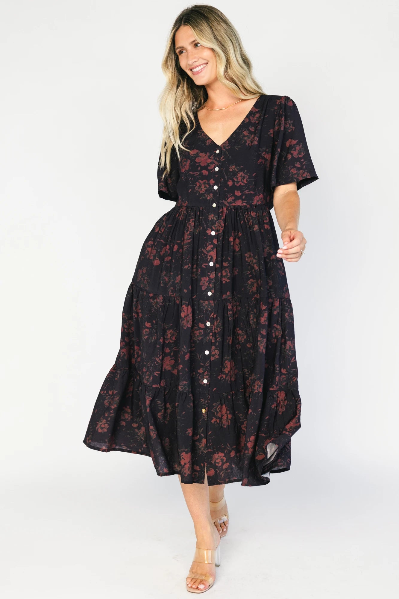 Deep plum midi dress with a V-neckline, functional button-front bodice, puff sleeves, an elastic back waist, and a flowing tiered skirt.