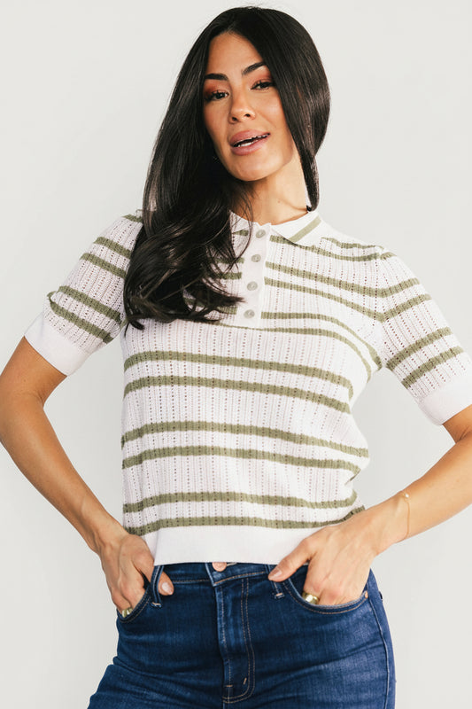 Front view of Bahía knit stripe top in sage and off-white worn by a model, showing the collared neckline, four functional buttons, and ribbed cuffs.