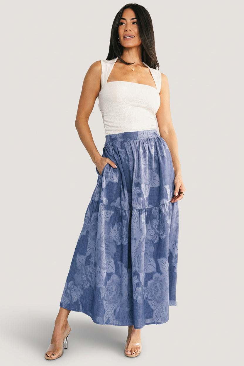 Styled look: Alejandra midi skirt in blue floral paired with a light top, showing versatility from daytime casual to evening styling.