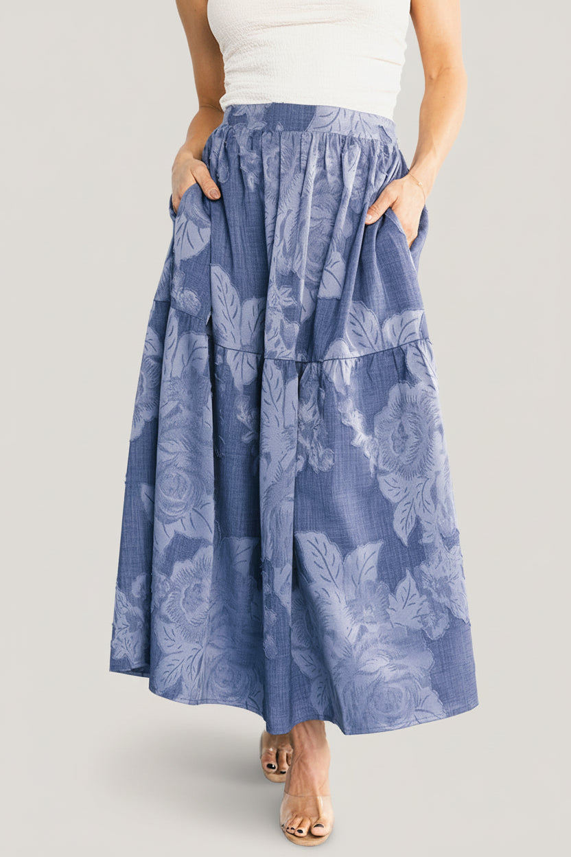 Front view of Alejandra midi skirt in blue floral, A-line silhouette with smocked back waist and functional side pockets visible.