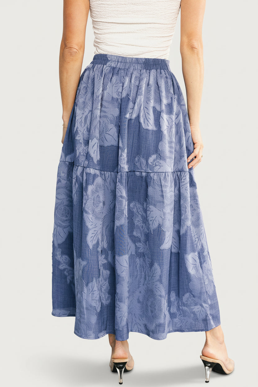 Close-up of Alejandra skirt fabric detail highlighting subtly raised floral texture and denim-look weave in blue tones.
