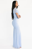 Close-up detail of draped shoulder overlay and ruched bodice on the light blue Serenade Maxi Dress, showing fabric texture and stitching.