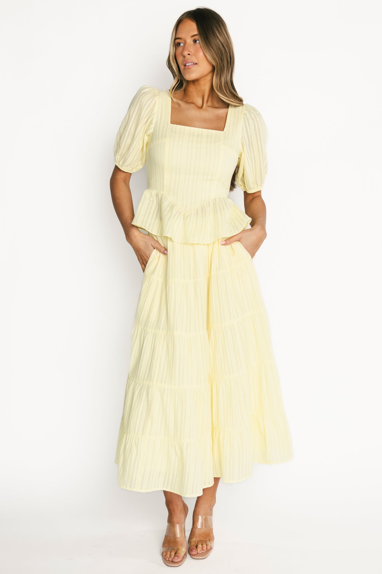 Model wearing the Candace light yellow square-neck top and tiered skirt, front view showing peplum hem and puff sleeves.