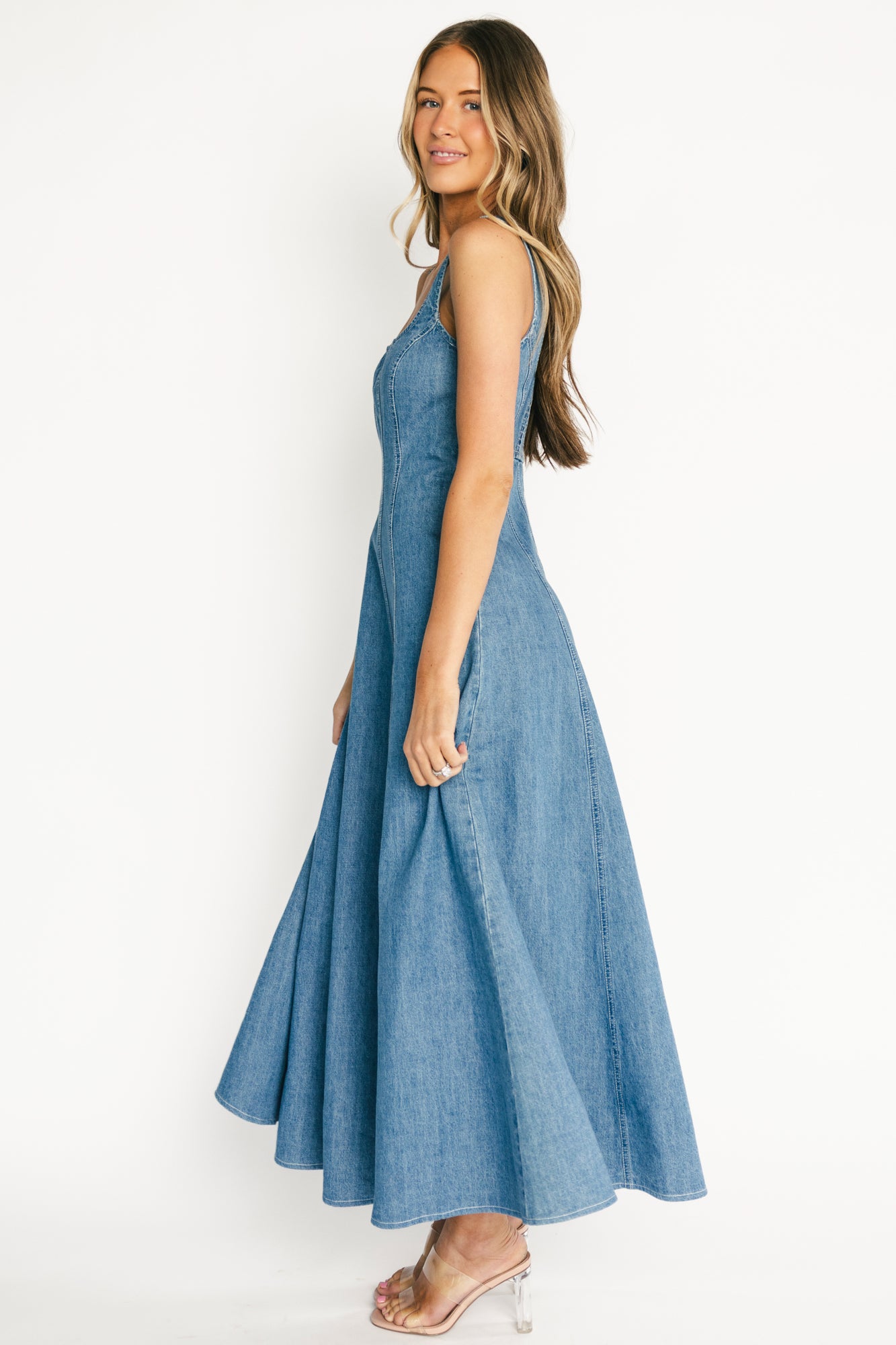 Close-up of fitted bodice and vertical seam detailing on medium wash denim fabric, showing texture and tailored fit.