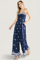 Front view of Córdoba strapless wide-leg jumpsuit in navy with off-white abstract print, showing strapless neckline and flowing silhouette.