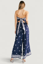 Side angle of Córdoba jumpsuit showing hidden side pocket, relaxed fit through the hip, and wide pant leg movement.