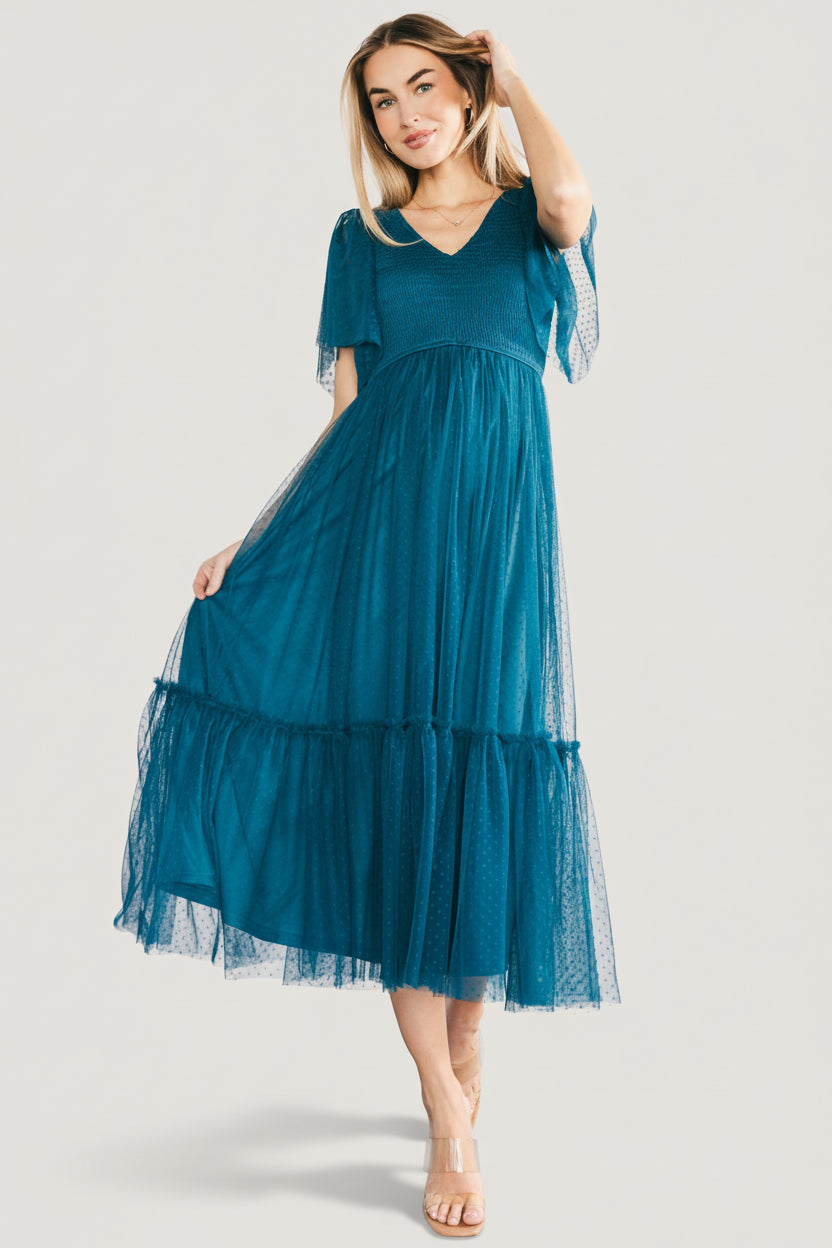 Front view of teal Martha smocked tulle midi dress on model showing V-neck, smocked bodice, and single-tier ruffled skirt in teal.