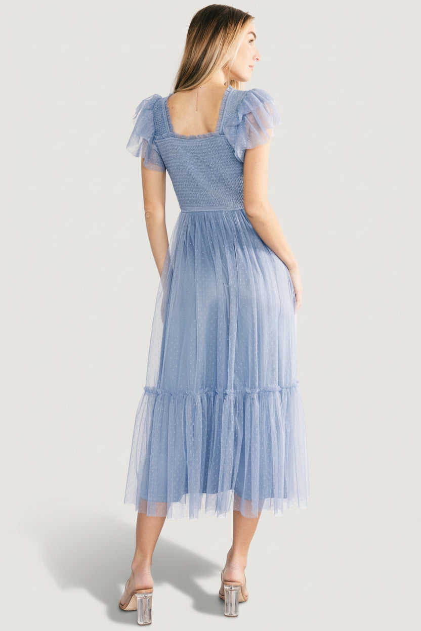 Side view of the Elowyn midi dress in blue showing the straight-cut neckline, layered flutter sleeve, and graceful tiered skirt movement.