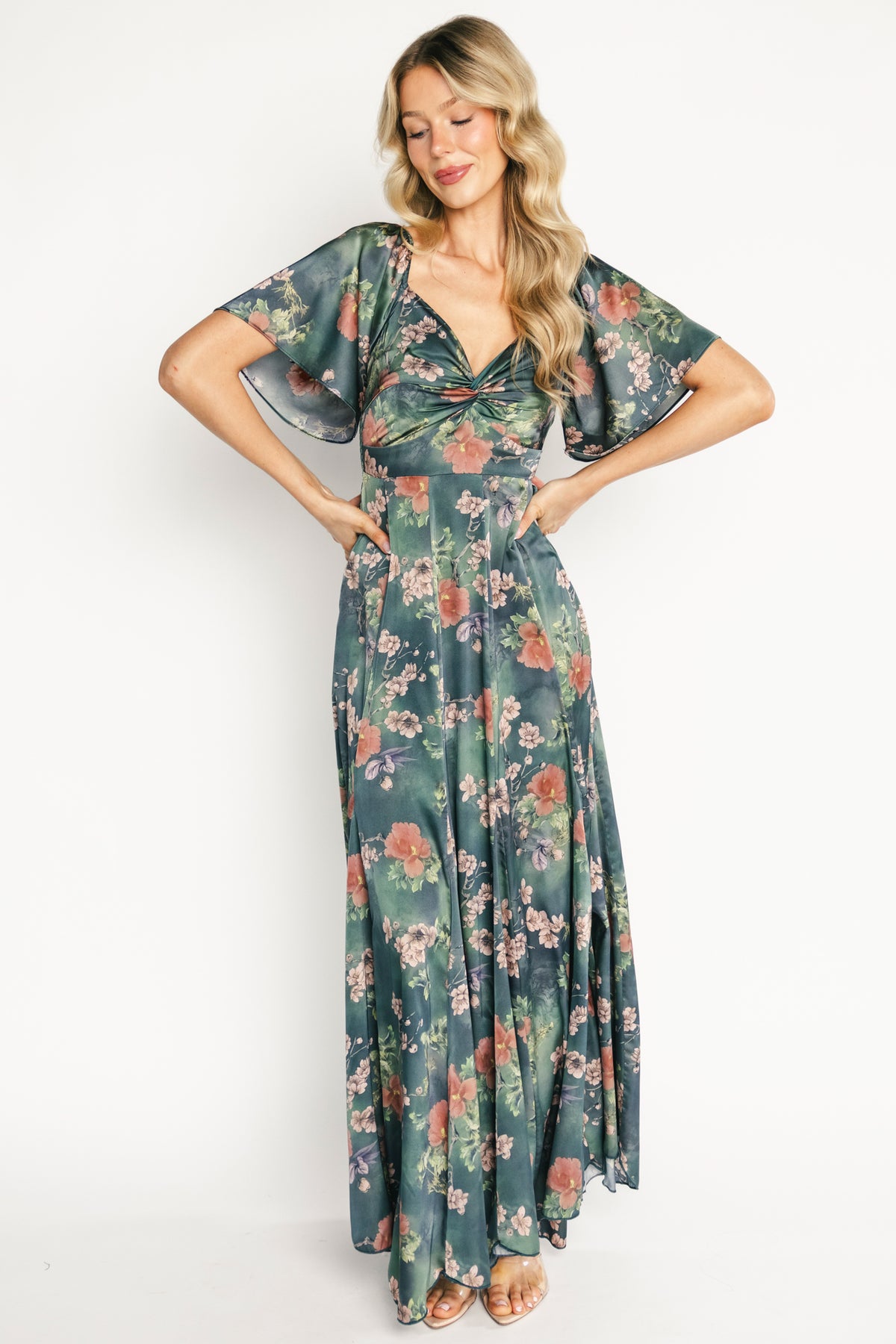 Model front view wearing dark green floral Caterina maxi dress, showing knotted sweetheart bust and empire waist.