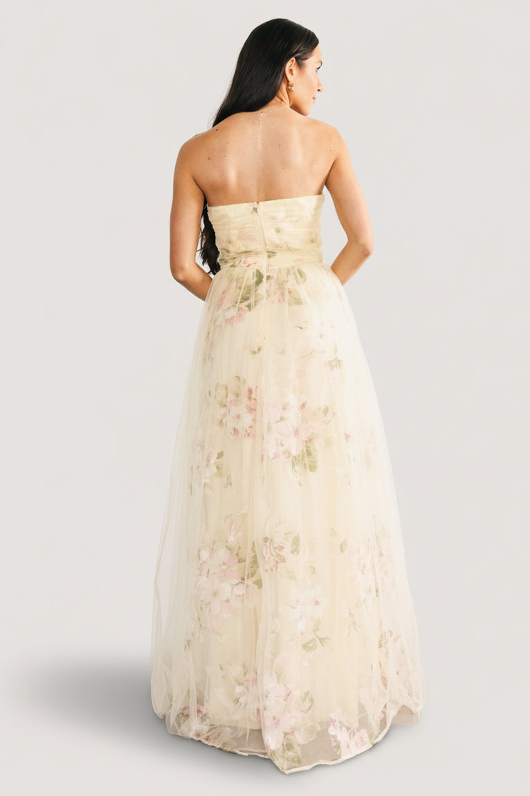 Side view of the layered tulle overlay and gown-length skirt of the Carlotta dress, showing movement and floral print in natural light.