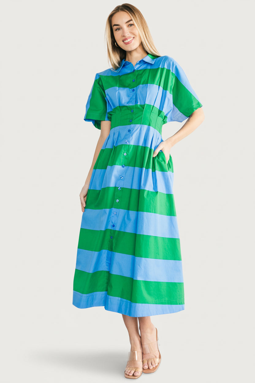 Detail image showing waist pleating, fabric drape and hidden side pocket opening on the blue and green striped shirt dress.