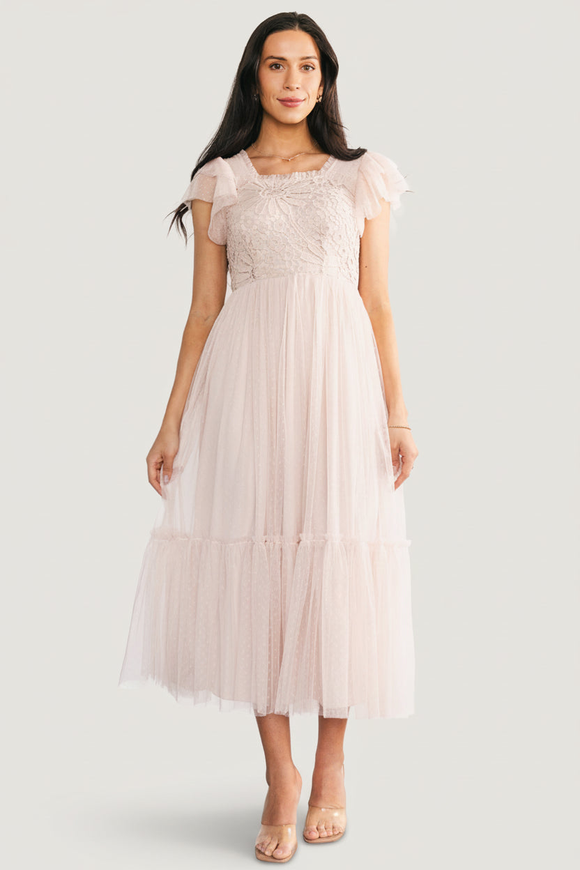 Back view of Elowyn midi dress showing the smocked back panel for stretch, unlined sheer sleeves, and the single-tier skirt in a soft natural tone.