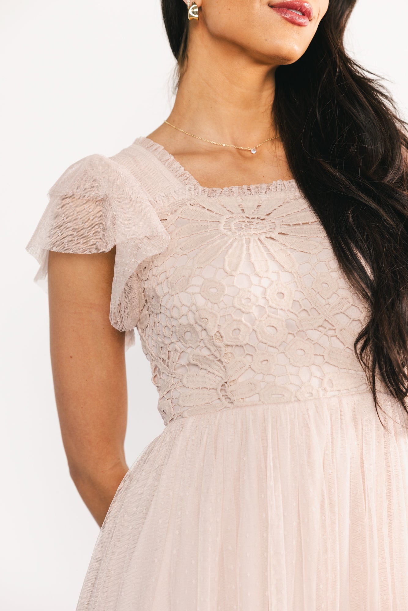 Three-quarter view of Elowyn dress in natural showing smocked back panel, single-tier midi skirt and delicate Swiss dot mesh with lace trim on the bodice.
