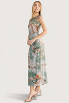 Styled shot of Daniela Mesh Midi Dress in dusty sage floral paired with sandals to illustrate casual evening wear.