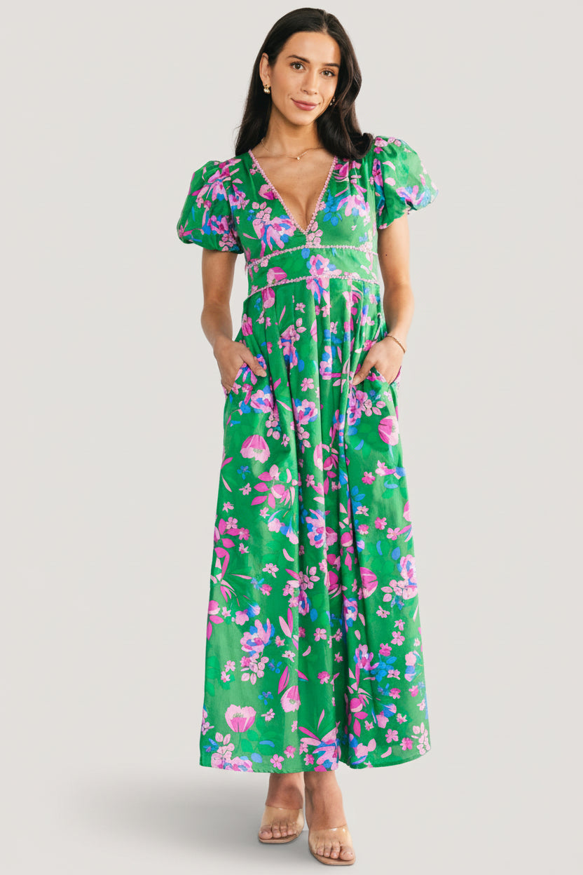 Front full-length view of the Anya Maxi Dress in green multi floral print showing lace-trim V-neck and short puffed sleeves.