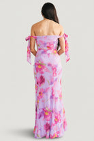 Back view showing concealed zipper and adjustable off-shoulder straps tied into delicate bows on the chiffon maxi dress.