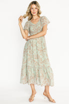 Front view of Monica Smocked Maxi Dress in dusty sage with terracotta floral print, V-neck, smocked bodice and flutter sleeves.