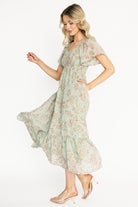 Side profile of the dress showing hidden side pocket placement and the maxi skirt's single bottom tier movement in dusty sage.