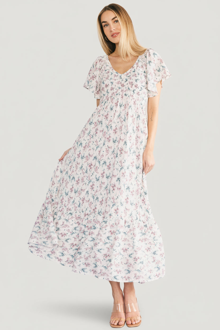 Close-up of the smocked bust and flutter sleeve on the Joanie dress, highlighting center seam, delicate floral print, and lightweight rayon texture.