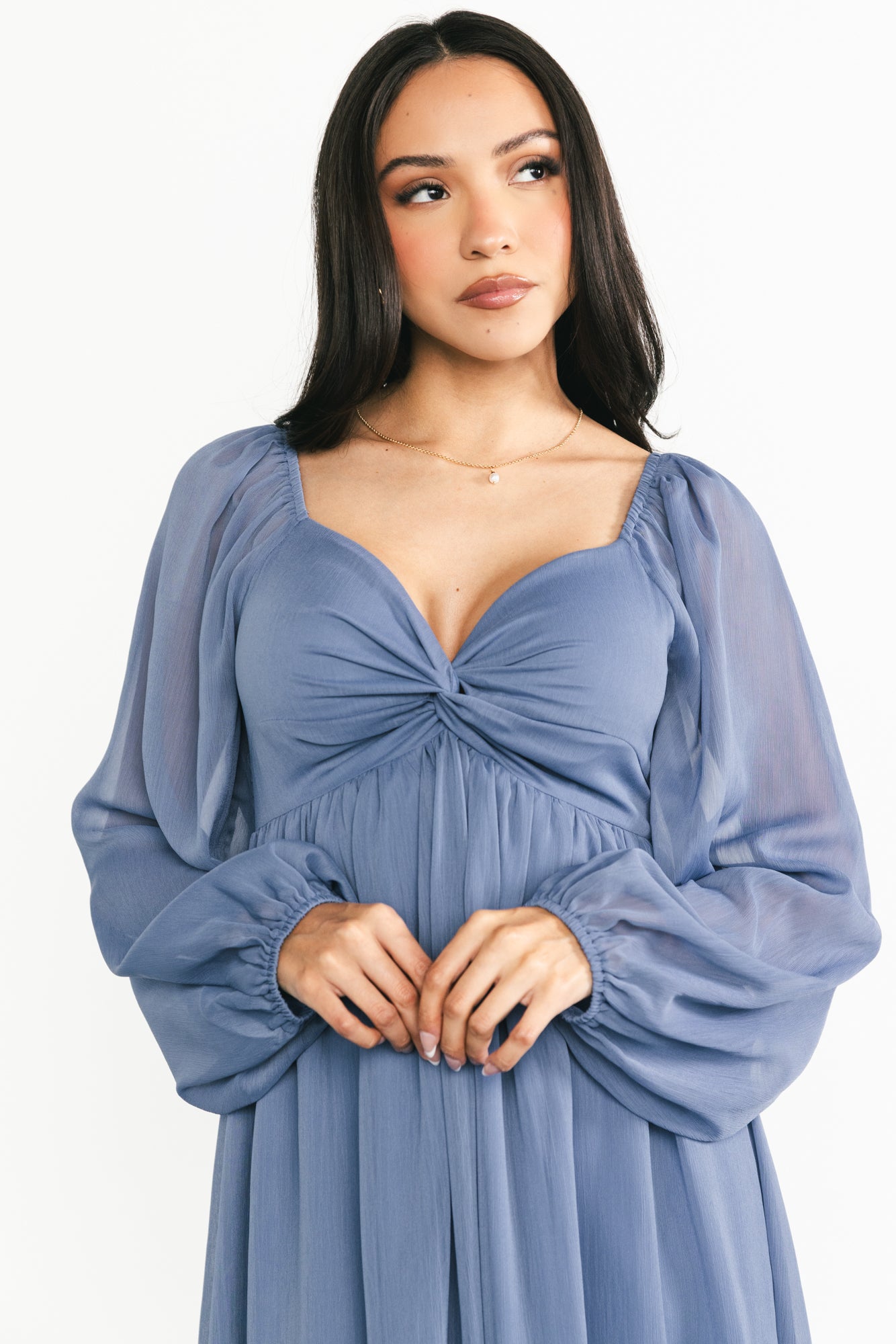 Full-length image of the Dione midi dress in dusty blue, styled with low heels to show true midi length and movement.
