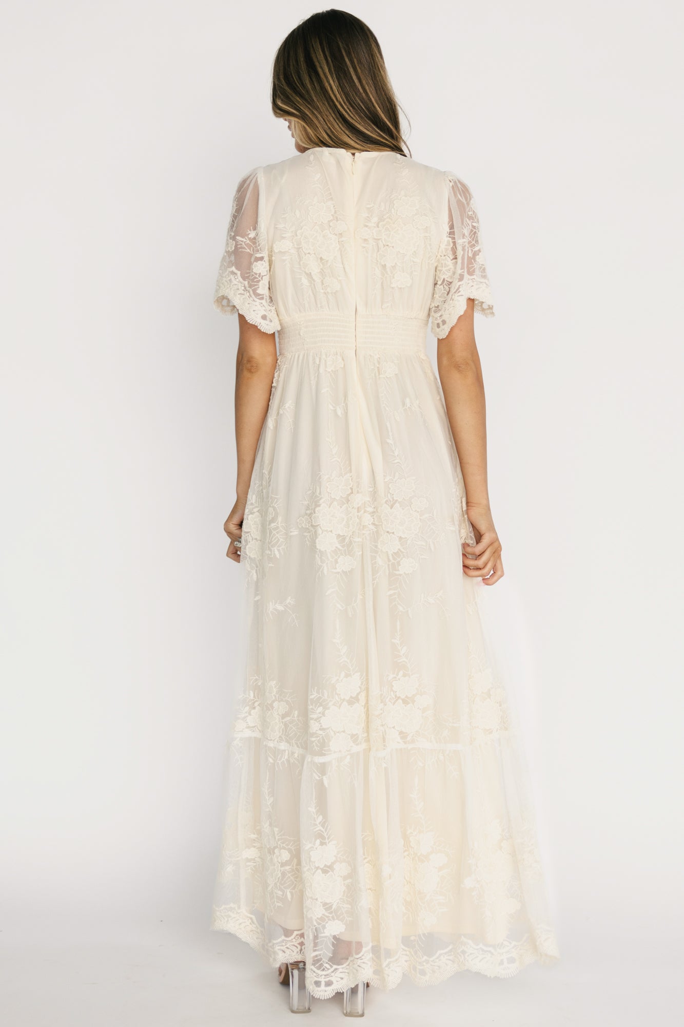 Back view of Rosalia Lace Maxi Dress displaying back zipper with hook-and-eye, smocked waist panel, and scalloped hemline detail.