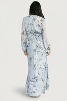 Back view of the maxi dress on model highlighting empire waist with back elastic band and attached waist tie.