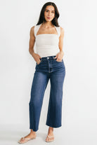 Detail shot of the raw hem and cropped ankle finish on the Kirby dark wash wide-leg jeans, showing fabric texture and edge fraying.