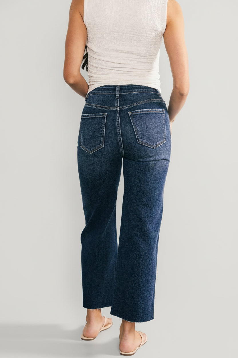 Back view of Kirby dark wash high-rise wide-leg jeans on model, showing rear pockets, fit through the seat, and cropped length at the ankle.