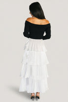 Side view of dress showing A-line silhouette and layered ruffle tiers of the white satin skirt with lined interior.
