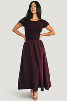Front view of model wearing Angelique Midi Dress in mulberry; ribbed sweater top, drop-waist elastic band, thick jersey midi skirt