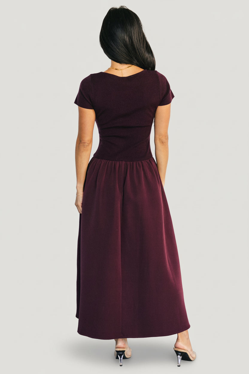 Detail of drop-waist elastic band and seam where the ribbed top meets the structured jersey skirt in rich mulberry