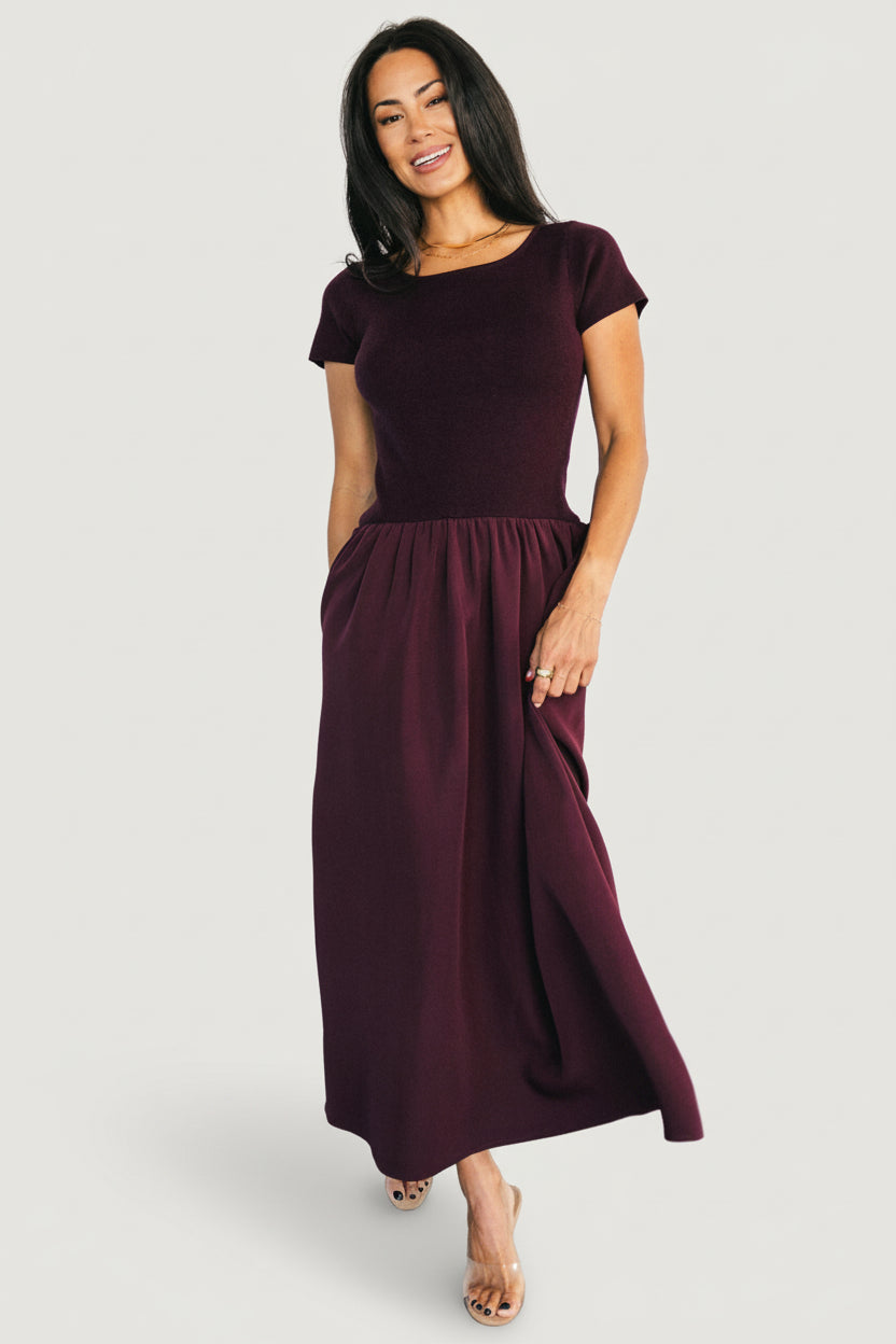 Styled full-length image of Angelique Midi Dress with accessories, illustrating versatile day-to-night outfit in deep mulberry