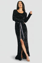 Back view of model in the Julia sequin velvet dress showing long sleeves, fitted back silhouette and gown-length hem.