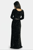 Close-up detail of monochrome sequins on soft black velvet, showing texture and stitchwork along the gown's bodice.